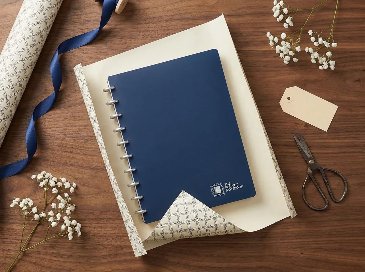 The Gift Set — blue Perfect Notebook on gift wrap with ribbon, scissors, tag, and baby's breath